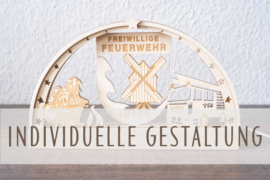 LED-Schwibbogen aus Holz mit Wohnwagen-Motiv vor Bergkulisse mit Sonne, Sternen und Tannen, davor Campingstühle und Tisch, warmweiß beleuchtet, mit Schriftzug „Camperleben" auf der Holzleiste